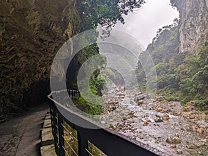 Dark and empty Shakadang Trail goes under a cliff alongside Liwu River in a mist during the pandemic before 403