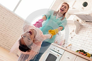 Dark-eyed daughter feeling amazing cleaning flat with mother