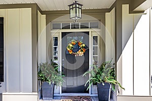 A dark fornt door and porch of a new construction house