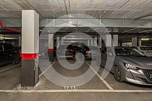 A dark garage with parked cars and free spaces