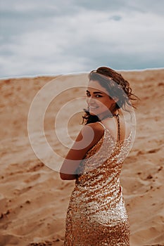 Dark girl with voluminous curly hair among the Sands in the sand dune