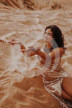 Dark girl with voluminous curly hair among the Sands in the sand dune