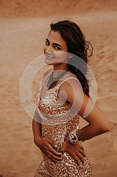 Dark girl with voluminous curly hair among the Sands in the sand dune