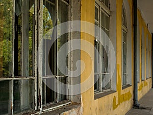 Dark gloomy atmosphere of a lonely yellow house with broken windows