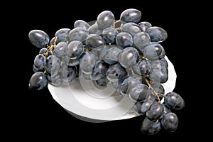 Dark grapes on a white plate