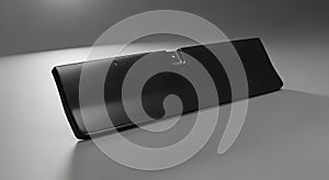 A dark gray rectangular object resting on a light gray surface in studio shot