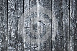 Dark gray wood fence. Shabby table. Old grey wooden boards. Pattern of cracked planks. Strips on wood surface. Dilapidated boards