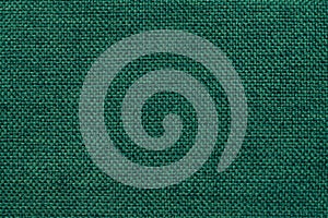 Dark green background of dense woven bagging fabric, closeup. Structure of the textile macro.