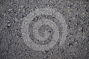 A dark grey asphalt pavement texture. Ð¡lose-up of the repair of the road