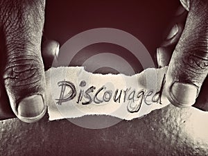 on the dark grey background the word discouraged written by hand photo