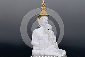 Dark grey clouds as backdrop for the five white sitting Buddhas at Wat Pra That, Pha Sorn Kaew, in Khao Kor, Phetchabun, Thailand