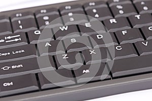 A dark grey computer keyboard set close up photo