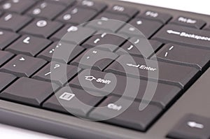 A dark grey computer keyboard set close up photo