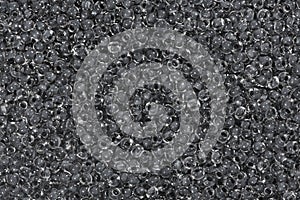 Dark grey glass seed beads background.