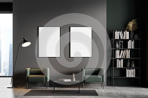 Dark grey modern living room interior with panoramic window furnished by green armchairs, coffee table, bookshelf, lamp and two