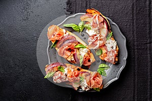 A dark grey plate with with open sandwiches, snack. Toastet bread photo