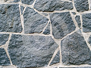 Dark grey rocks texture background. Black rock wall texture