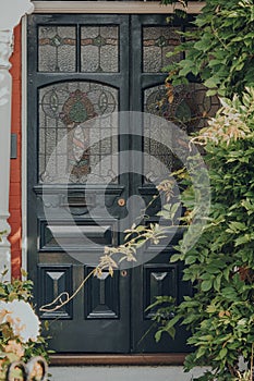 Dark grey stained glass door of an Edwardian house in London, UK