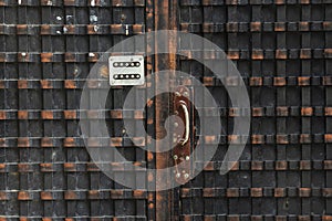 Dark grunge metal door with combination lock close up.