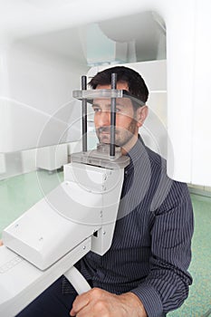 Dark hair man with beard waiting for an x-ray of his teeth. photo