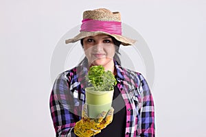 Dark Hair Woman in Garden Outfit Holds a Fresh Herb