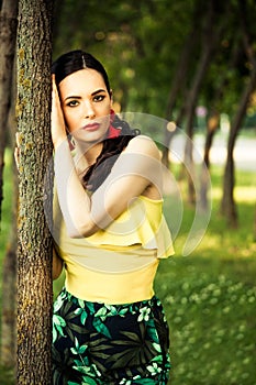 Dark hair woman portrait by the tree latino look