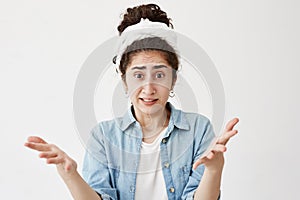 Dark-haired annoyed angry woman in do-rag holding hands in furious gesture. Young female in white T-shirt expresses