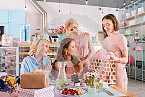 Dark-haired anticipating woman receiving presents for her little baby girl