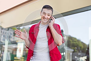 Dark-haired beaming man feeling involved in phone discussion