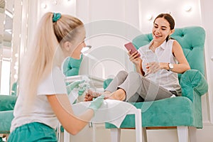 Dark-haired beaming woman communicating with her chiropodist