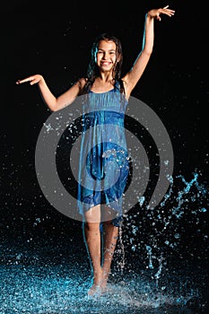 Dark-haired brown-eyed teenage girl posing in a black aqua-zone.