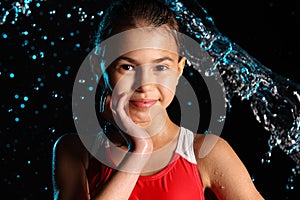 Dark-haired brown-eyed teenage girl posing in a black aqua-zone.