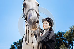 Dark-haired businesswoman loving equestrianism coming to race track