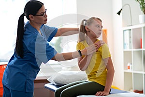 Dark-haired doctor in blue uniform presenting special movements