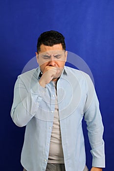 Dark-haired Latino adult man is sick, has a sore throat and suffers from strep cough and tonsil infections