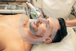 Dark haired man enjoying oxygen meso therapy