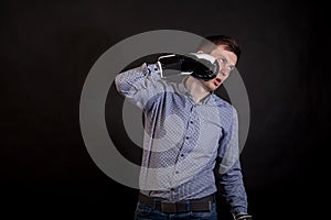 Dark-haired man in a plaid shirt with boxing gloves on his hands stabs