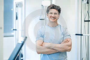 Dark-haired smiling physical therapist looking confident