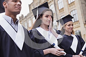 Dark-haired student feeling touchy on her graduation day