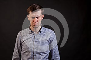 A dark haired white man with a distrust expression face