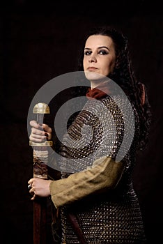 A dark-haired woman with a sword, a Scandinavian warrior in a chain mail against