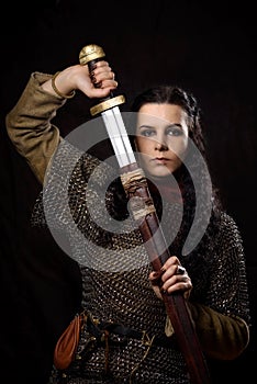 A dark-haired woman with a sword, a Scandinavian warrior in a chain mail against