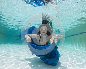 A dark haired women model in various outfits underwater