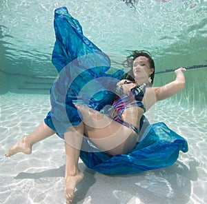 A dark haired women model in various outfits underwater