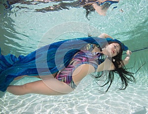 A dark haired women model in various outfits underwater