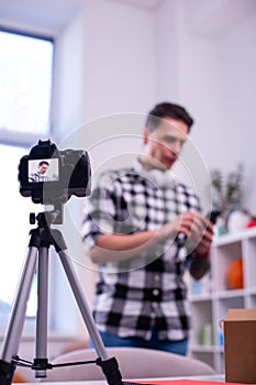 Dark-haired young man shooting new video for his channel