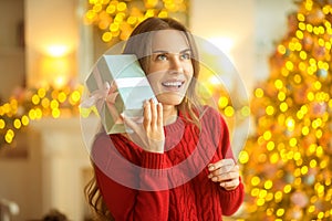 Dark-haired young woman holding a christmas gift