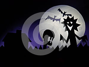 Dark Halloween season background with moon in the background and scary creatures silhouettes. Alien scull, bats, and funny monster