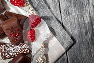 Dark handmade chocolate stack with raspberries and nuts