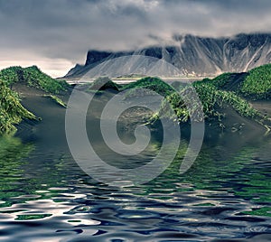 Dark hills of Vestrahorn peak reflected in calm waters of Atlantoc ocean.